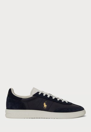 Navy blue and white low-top sneaker with white laces, gold Polo Ralph Lauren logo on side, and white rubber sole.