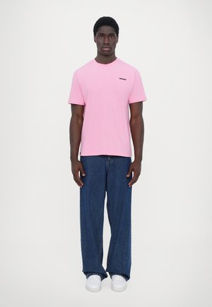 Lyserød bomulds T-shirt med korte ærmer og rund hals, parret med blå vide denimjeans og hvide sneakers.