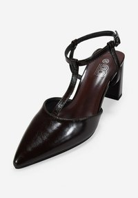 Zapatos de tacón T de piel negra con punta afilada, superficie texturizada y tacón cuadrado, con un logo en el interior de la plantilla. Talla 36.