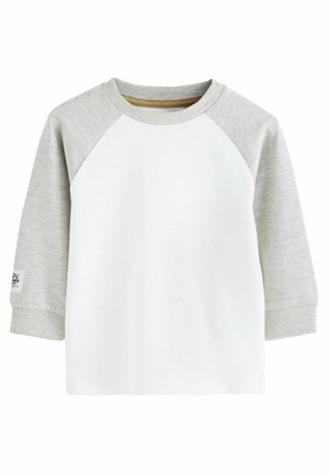Langarm-T-Shirt mit einem weißen Körper und grauen Raglanärmeln. Mit einem gerippten Kragen und Bündchen. Aus weichem Baumwollmaterial mit einem Etikett am Ärmel.