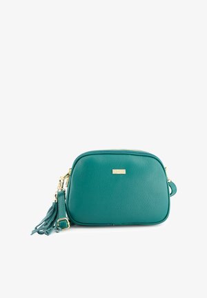 Turkooise leren crossbodytas met gouden accenten, ritssluiting en een decoratieve kwast. Ronde vorm met gestructureerd oppervlak en logodetail.