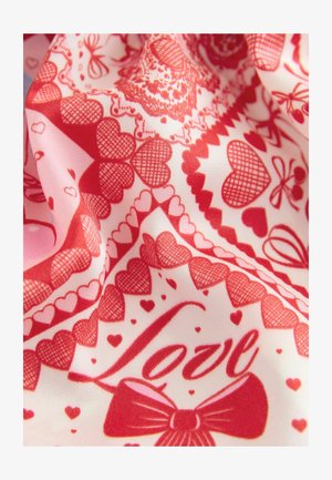 Red and pink fabric with a pattern of hearts, bows, and the word "Love," creating a textured, layered appearance.