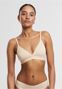 Nude triangular bikini top with spaghetti straps. Smooth fabric with a V neckline and a wide underbust band. Minimalist design.