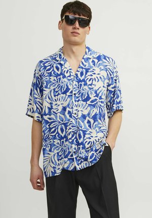 Blue and white short-sleeve shirt with floral pattern, lightweight fabric, button closure, and open collar design. Worn with black pants.