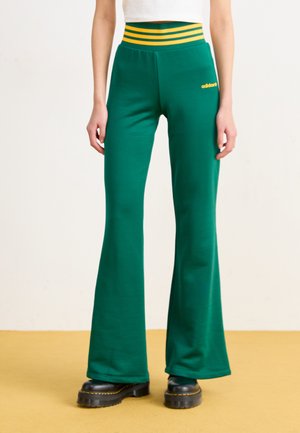 Groene uitlopende sweatpants met een geribbelde gele en groene gestreepte tailleband. Voorzien van een geborduurd logo op de linkerdij en een zachte stoftextuur.