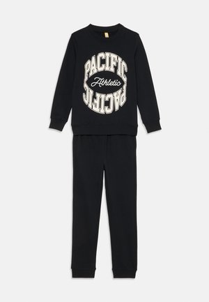 Czarny komplet składający się z bawełnianej bluzki i spodni, z okrągłą grafiką "PACIFIC Athletic" w kolorze kremowym. Żebrowane mankiety i spodnia część dla zapewnienia wygody.