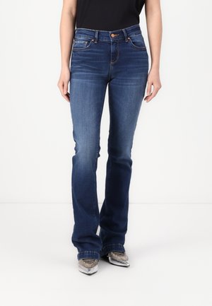 Dark blue flared jeans with subtle fading, five-pocket design, and copper rivet accents, paired with metallic gray shoes.