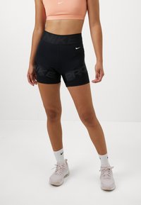 Shorts Nike Pro neri con vita alta e branding tonale. Tessuto liscio e elasticizzato con una vestibilità aderente, ideale per l'abbigliamento sportivo.