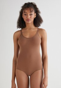 Bruine bodysuit met dunne bandjes, gemaakt van zachte stof. Slim fit ontwerp, naadloze randen en gematigde bedekking aan de onderzijde.