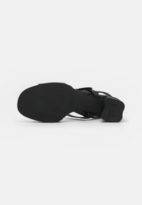 Black sandal with a textured sole, featuring strappy design. The heel is block-shaped and smooth, providing stable support.