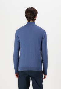 Blue knit sweater with long sleeves, a high collar, and ribbed hem. Soft texture, seamless design, and even color.