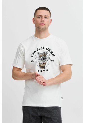 Hvid bomulds t-shirt med korte ærmer, der viser et grafik af en vaskebjørn med solbriller, der holder mad, ledsaget af sort tekst.