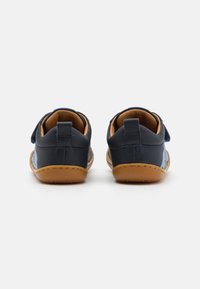 Navyblaue Leder Schuhe mit hellblauen Akzenten, runder Form und braunen Gummisohlen. Sie verfügen über einen Klettverschluss für ein einfaches Anziehen.