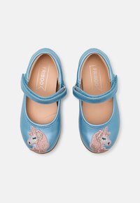 Niebieskie buciki typu Mary Jane dla małych dzieci z ró�żowym haftem jednorożca i zapięciem na rzepy na białym tle.