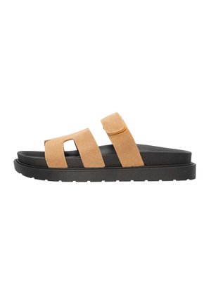 Tan suede slide sandals with two wide straps and adjustable Velcro closure. Black sole with textured grip, featuring a layered design.