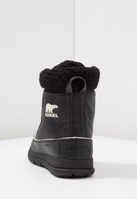 Black waterproof winter boot with textured fur collar, padded upper, white logo, sturdy rubber sole, and rear pull tab for easy wear.
