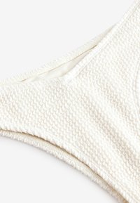 Kremno belo teksturirano spodnje plavalno oblačilo z vzorcem valov, elastičnim robom in gladko notranjo podlogo. Oblikovano za oprijet in udoben fit.