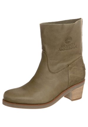 Skórzany botek w kolorze oliwkowej zieleni z niskim, warstwowym obcasem, zaokrąglonym noskiem i tłoczonym logo Shabbies Amsterdam na zewnętrznej górnej stronie.
