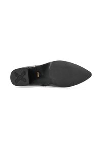 Semelle de chaussure en cuir noir avec une forme pointue, dotée d'une texture antidérapante et d'un logo discret près du talon. Conception plate pour plus de stabilité.