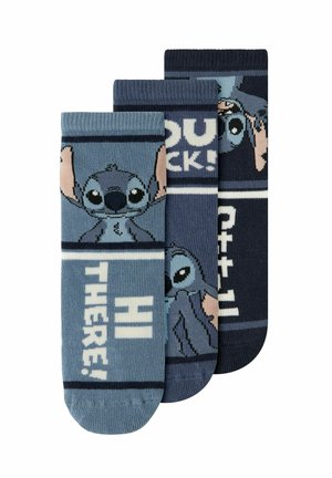 Trois paires de chaussettes bleues mettant en scène le personnage de dessin animé Stitch avec les textes "HI THERE!" et "YOU ROCKS!" dans différentes nuances de bleu et marine.