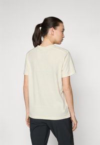 T-shirt kratkih rukava, s okruglim izrezom, u off-white tkanini. Ima jednostavan dizajn s opuštenim krojem i minimalnim šavovima, prikazan sa stražnje strane.