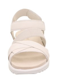 Helle beigefarbene Sandalen mit überkreuzten Riemen aus glattem Kunststoffmaterial, mit einem weichen Fußbett und einer weißen Gummisohle.