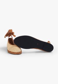 Espadrillas intrecciate con dettagli beige e lacci; presentano una tomaia in paglia naturale e suola in gomma nera; taglia 38.