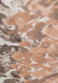 Textil mit einem abstrakten Muster in den Farbtönen Orange, Braun und Creme sowie einer strukturierten Stoffoberfläche.