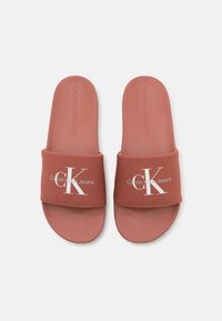 Infradito Calvin Klein Jeans in terracotta con una fascia in tessuto che presenta un logo bianco e una soletta liscia e testurizzata.