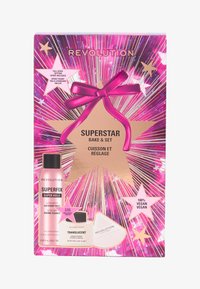 Revolution Superstar Bake & Set-kit med rosa og gull emballasje, som inkluderer spray og gjennomsiktig pudder, fremhevet med sløyfer og stjernesymbolet.