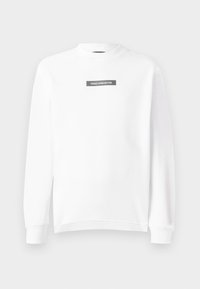 Felpa bianca a maniche lunghe con collo a giro e polsini e orlo a coste, caratterizzata da un piccolo patch rettangolare nero con la scritta "VERSACE JEANS COUTURE" sul petto.
