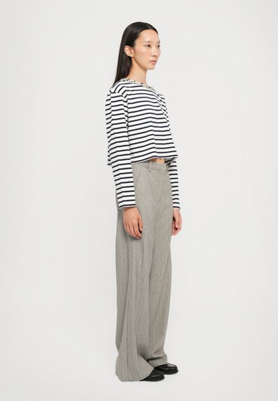 Striped long-sleeve cropped top in navy and white, paired with wide-leg gray pinstriped trousers, featuring a smooth texture and tailored fit.