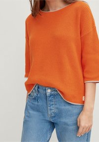 Suéter de punto naranja con un acabado texturizado, que presenta un corte relajado y mangas de tres cuartos. Ribete gris claro en el cuello y el dobladillo.