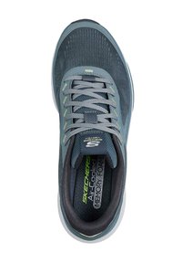 Zapatilla deportiva Skechers en gris oscuro, con parte superior de malla texturizada, cordones grises y detalles en verde. Plantilla de espuma con memoria para mayor comodidad.