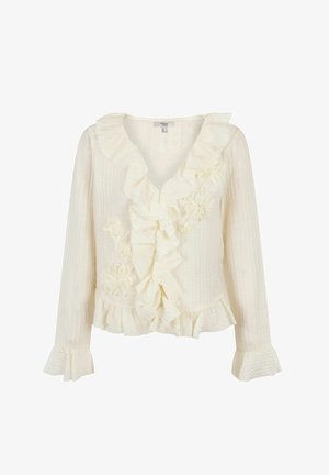 White long-sleeve blouse with a V-neck, ruffled neckline, front embellishments, and a flounced hem. Textured fabric with vertical stripes.