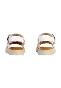 Sandales blanches avec plusieurs brides, une semelle plate et une semelle intérieure texturée. Équipées de quincaillerie métallique sur la bride ajustable.