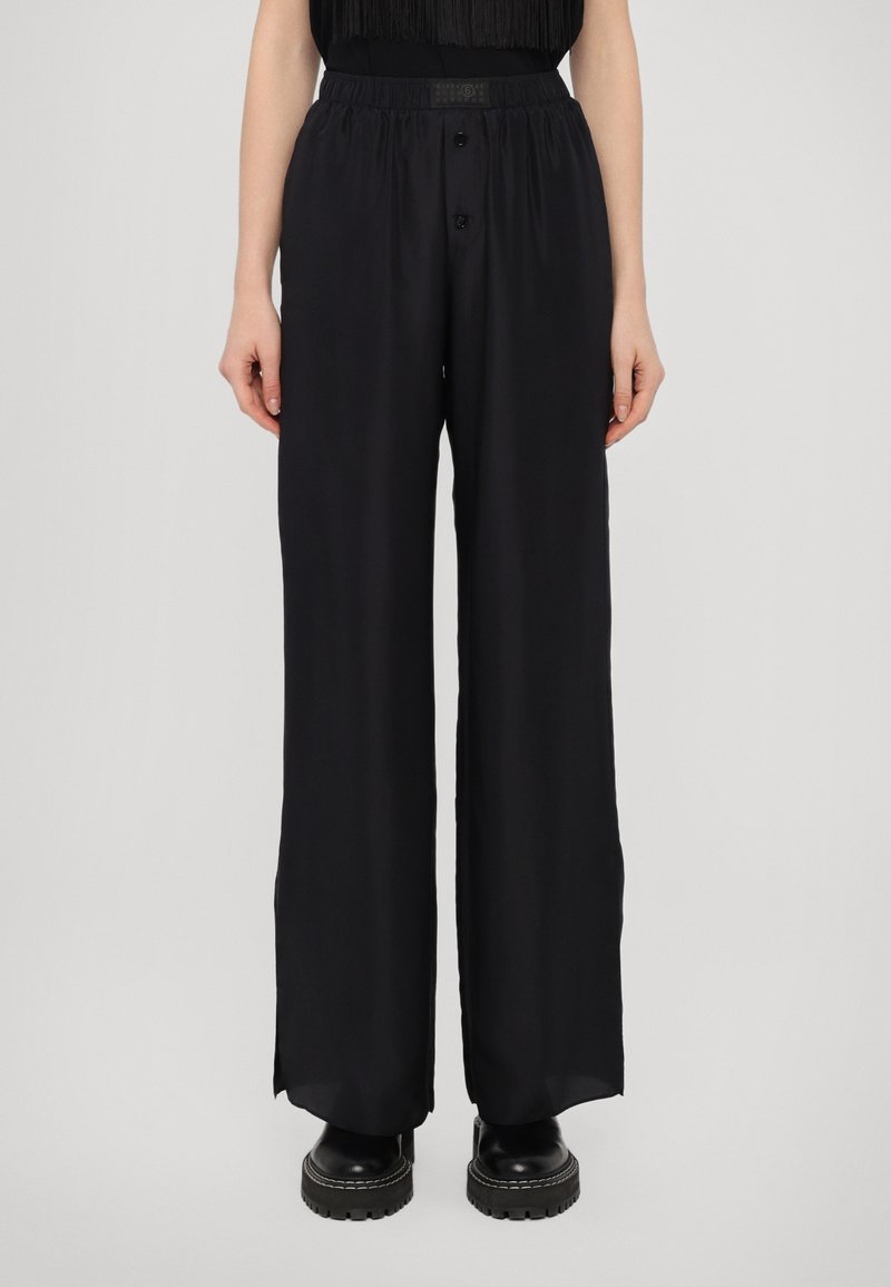 Black wide-leg trousers made of a smooth fabric, featuring a button closure and an elastic waistband for comfort. Suitable for various occasions.