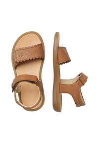 Sandali in pelle marrone con design della cinghia alla caviglia perforato, fibbia regolabile e suola beige liscia. Presentano bordi curvi e una soletta piatta.