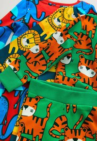 Farverige børnepyjamaser med legende dyremotiver: blå elefanter, orange tigre og gule løver på blødt bomuldsstof. Grønne detaljer.