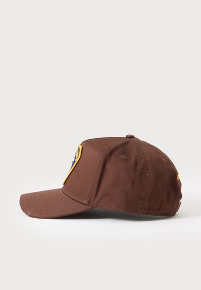 Casquette de baseball marron avec une visière incurvée et un patch coloré sur le panneau avant, vue de côté sur un fond uni.