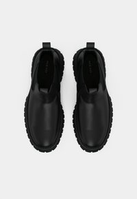 Mustad mustad nahast libisemiskingad tekstuurse viimistlusega, millel on robustne must tald ja kanna peal tõmbetooted, et neid oleks lihtne jalga panna.