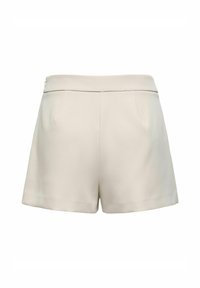 Shorts beige sur mesure avec une texture lisse, dotés d'une taille plate et de deux poches arrière. Design épuré et minimaliste sans quincaillerie visible.