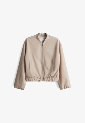 Beige Bomberjacke mit hohem Kragen, Reißverschluss vorne, elastischem Bund und Seitentaschen. Hergestellt aus glattem Stoff mit einem schlichten Design.