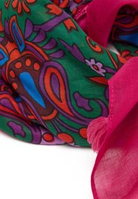 Kleurige sjaal met een levendig bloemen- en abstract patroon op een groene achtergrond, met een roze franjes detail langs de randen.