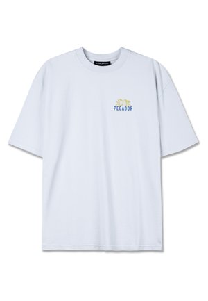 Light blue cotton t-shirt with a round neckline, short sleeves, and a small "PEGADOR" logo in blue and yellow on the chest area.