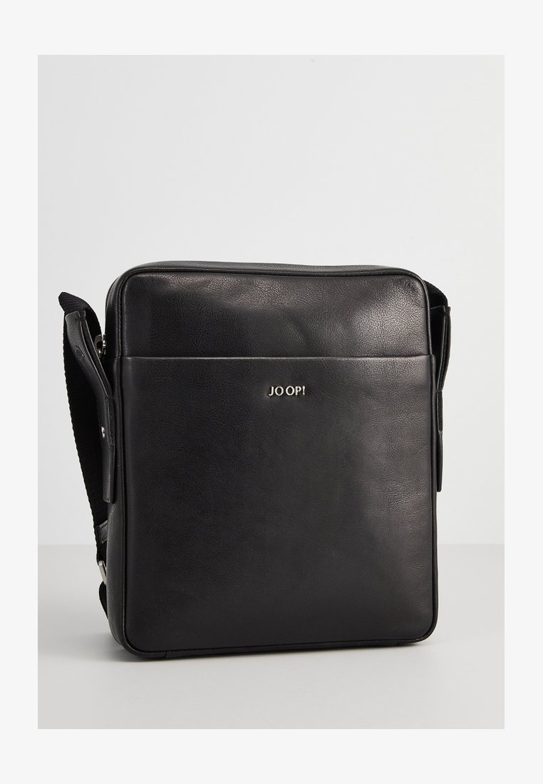 Sac en bandoulière en cuir noir avec une texture lisse, de forme rectangulaire, une sangle ajustable et un logo doré sur le devant.