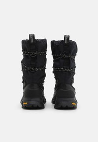 Svarte vanntette støvler med et teksturert stoffoverdel, elastiske bungee-lukkinger og gummisåle med Vibram-merke for bedre grep.