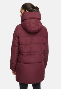 Burgundijas pūkains mētelis ar noņemamu kapuci, horizontāla quilted raksta dizains un logo uz muguras. Gluda tekstūra un vidēja garuma dizains.