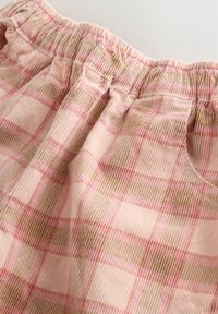 Rosa Karomuster mit hellen und dunklen Quadraten; weicher Stoff, elastischer Bund und geraffte Details am oberen Rand; dezente braune Akzente.