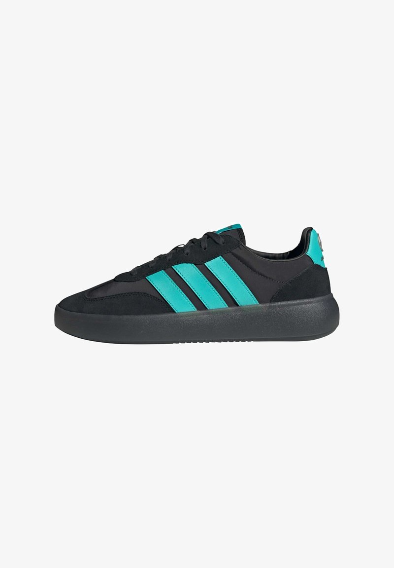 Black athletic shoe with turquoise accents, featuring a sleek design, smooth and suede textures, and three stripes on the side.